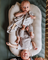 Bébés dans un lit avec doudou couleur greige.