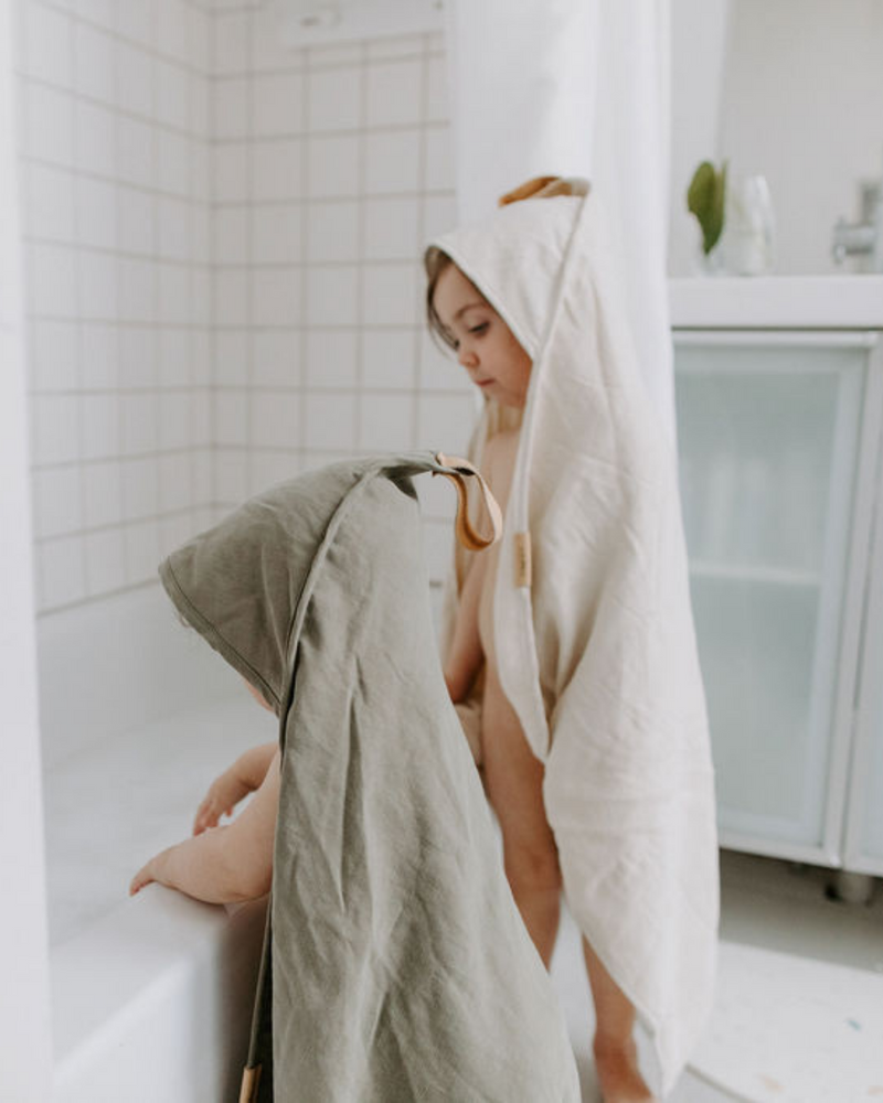 Enfants sortant du bain avec la serviette à capuche sauge et sable.